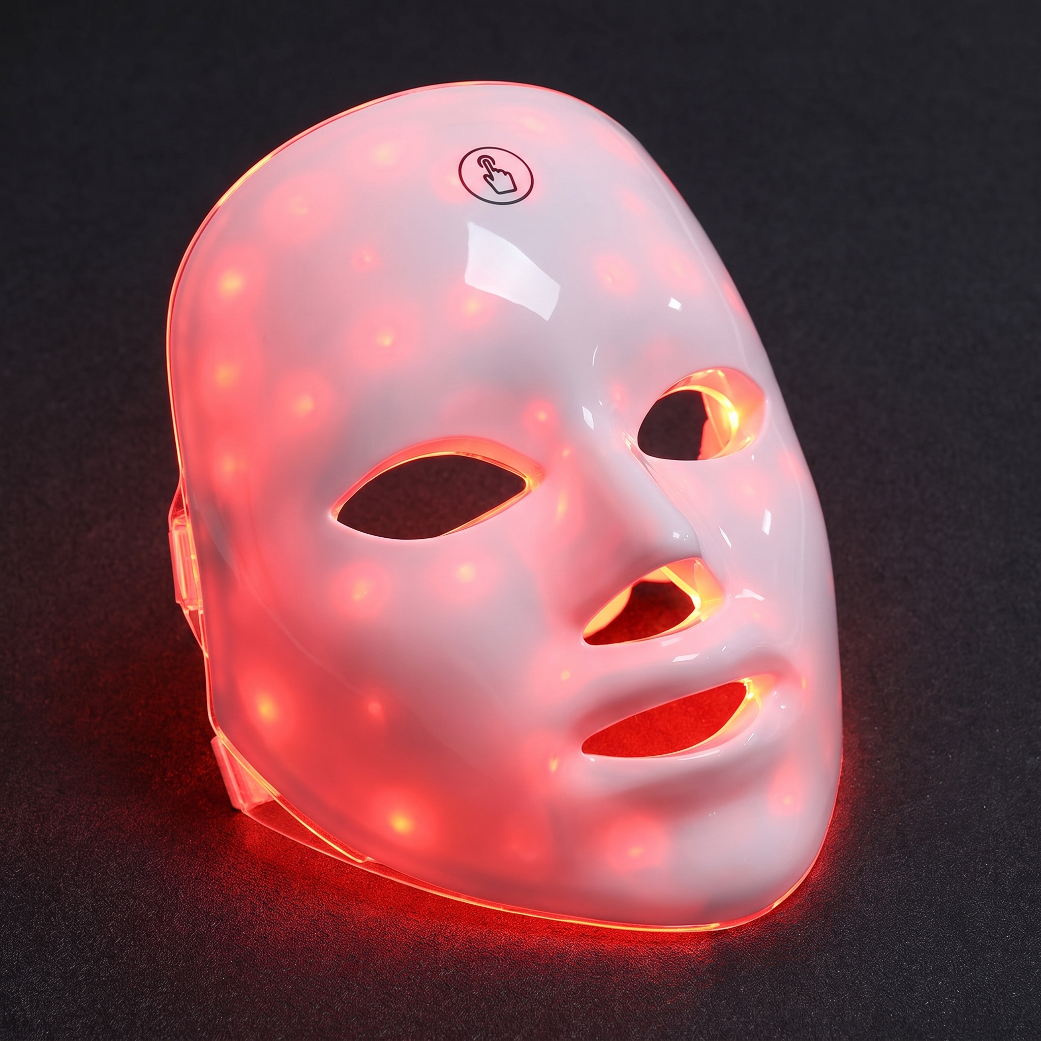 Close view of the mask powered on in its red 630nm setting, LED points glowing through the shell